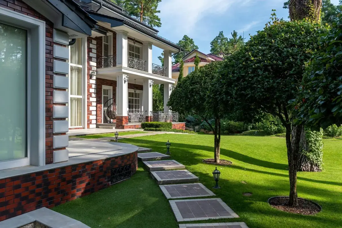 Großzügiger Garten mit Rasen, Stegen und altem Baumbestand am Haus